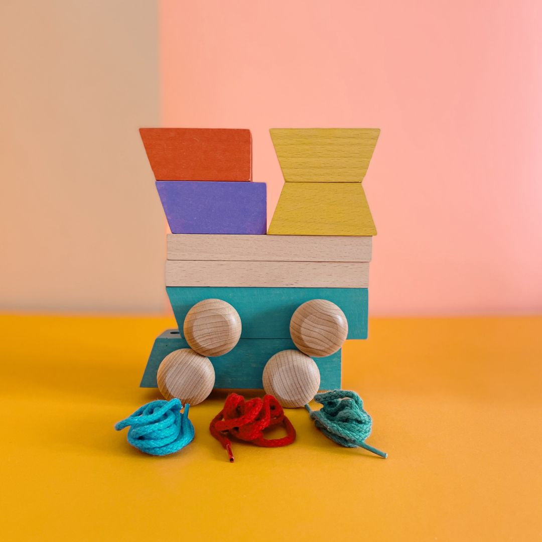 Blocks on wheels with strings for lacing