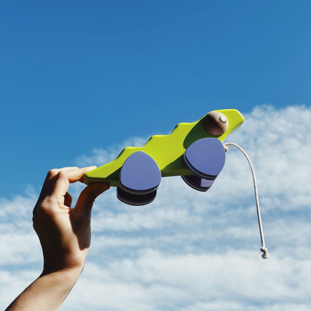 Iguana pull toy on triangular wheels